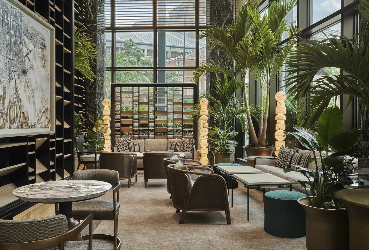 Tall windows and greenery in Chandelier Bar at Four Seasons New Orleans