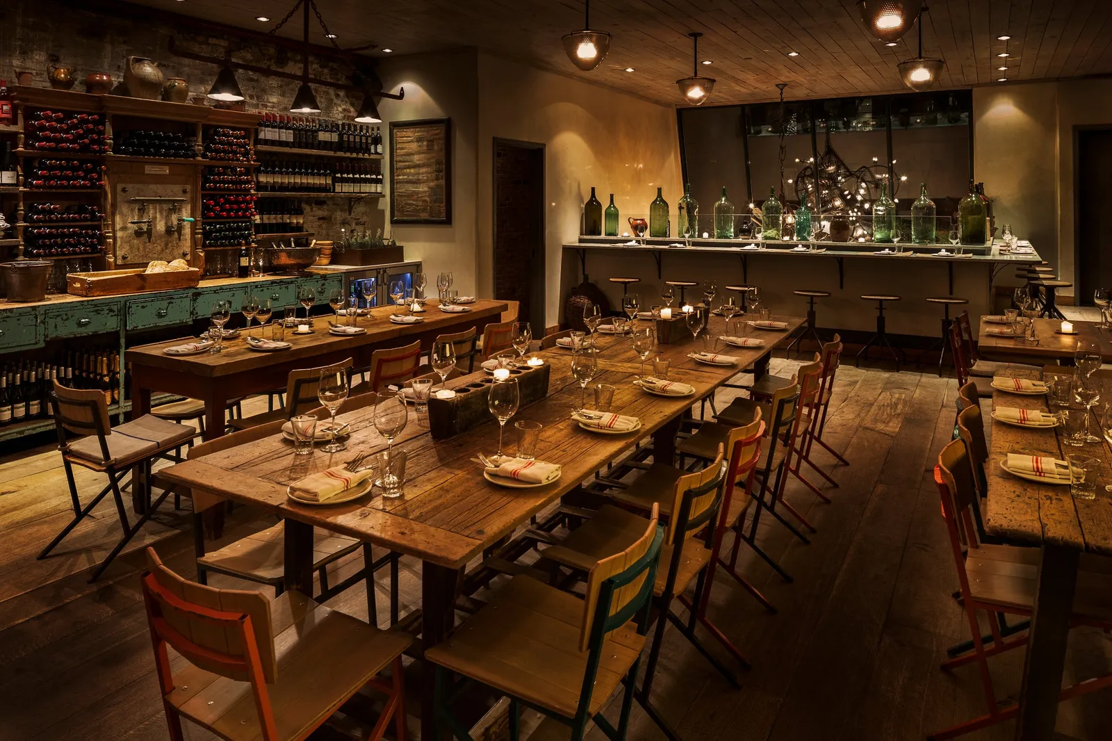 Wooden tables, wine shelves, and warm lighting in The Loft, the upstairs private dining room at Il Buco Alimentari