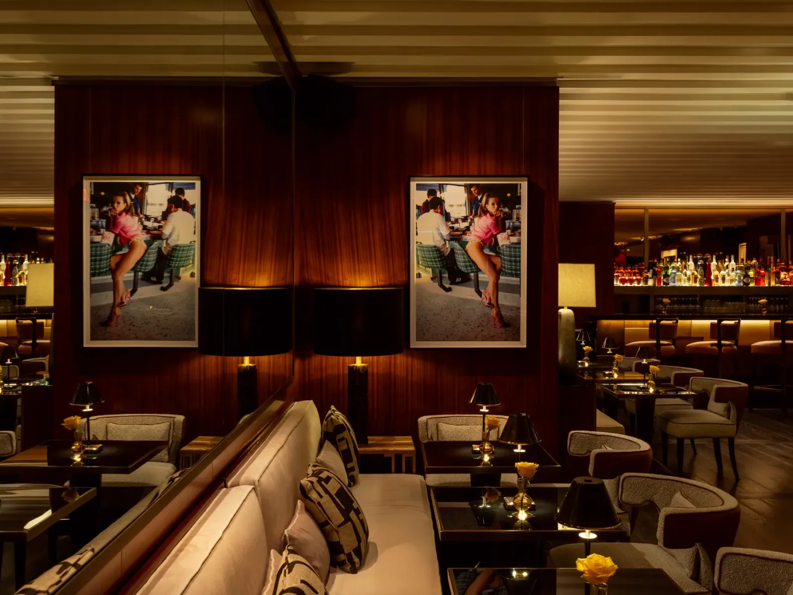 The softly lit Casa Tua lounge with striped banquettes, art, and the bar in the background