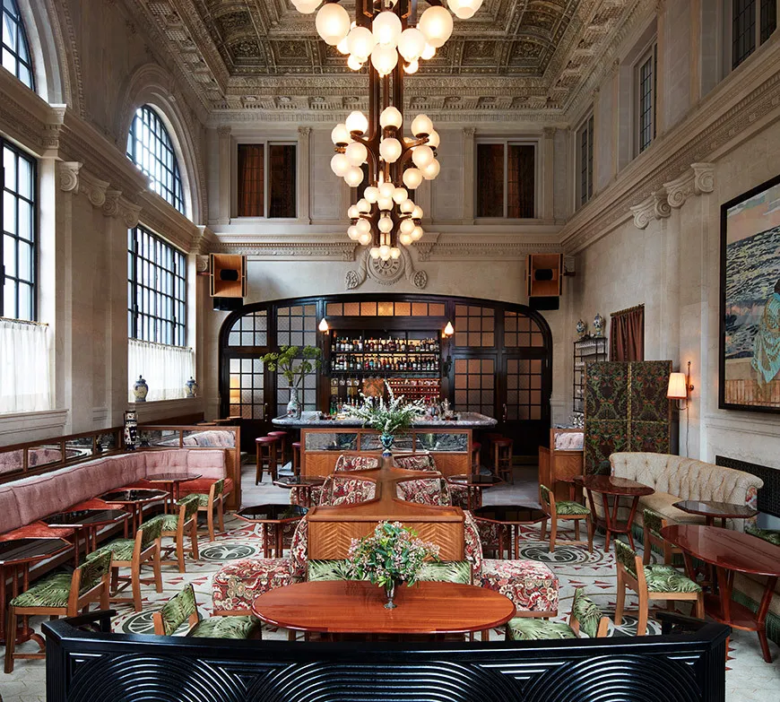 The vaulted Swan Room at Nine Orchard with chandeliers and red seating
