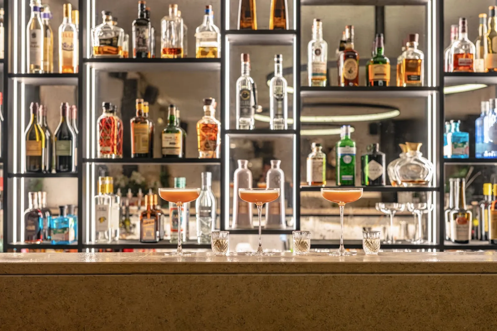 The bar counter and illuminated bottle shelves at Nespo